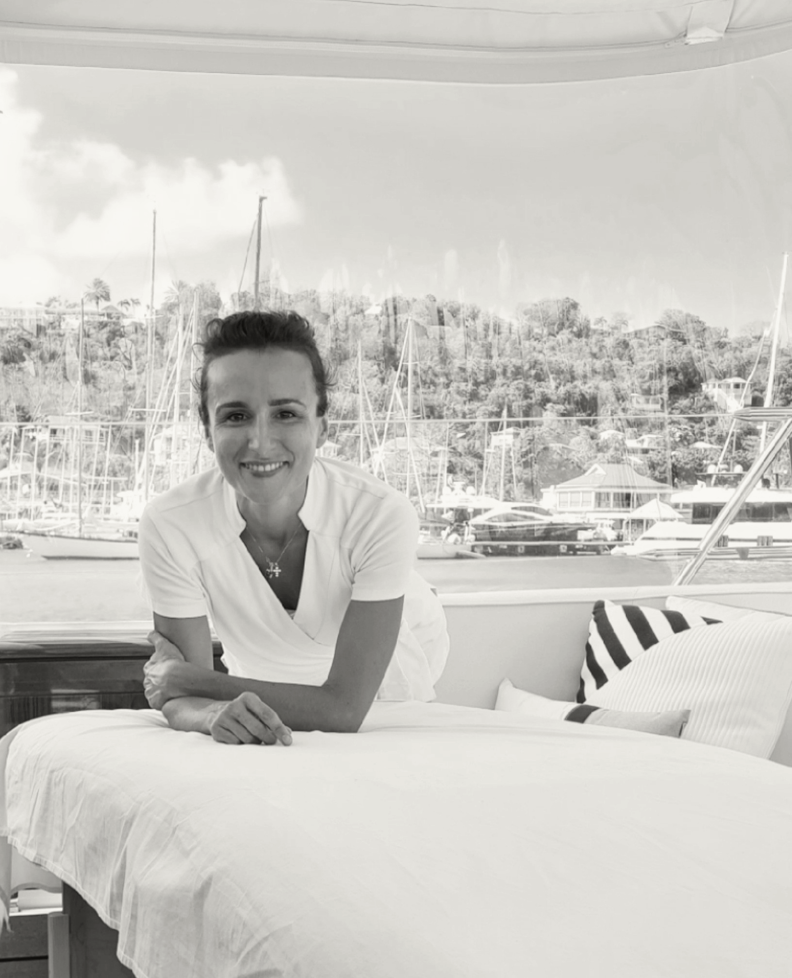 A professional wellness practitioner setting up a treatment area on the deck of a yacht